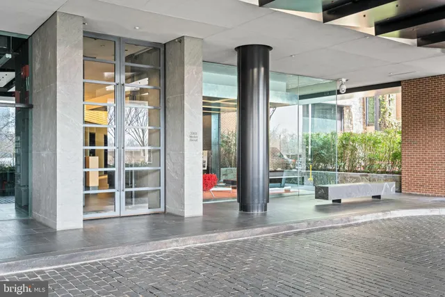 a view of a swimming pool with a chairs and table in a patio