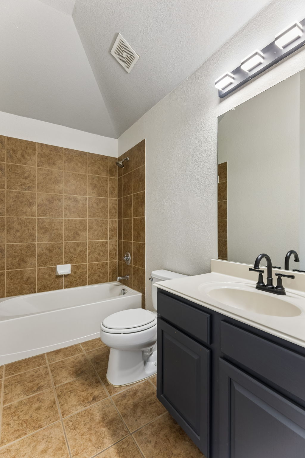 114 Aria Ridge, Unit 802 Lakeway, TX 78738 - Photo 14 of 37 A well-appointed bathroom features a tub, toilet, and a vanity with a large mirror.