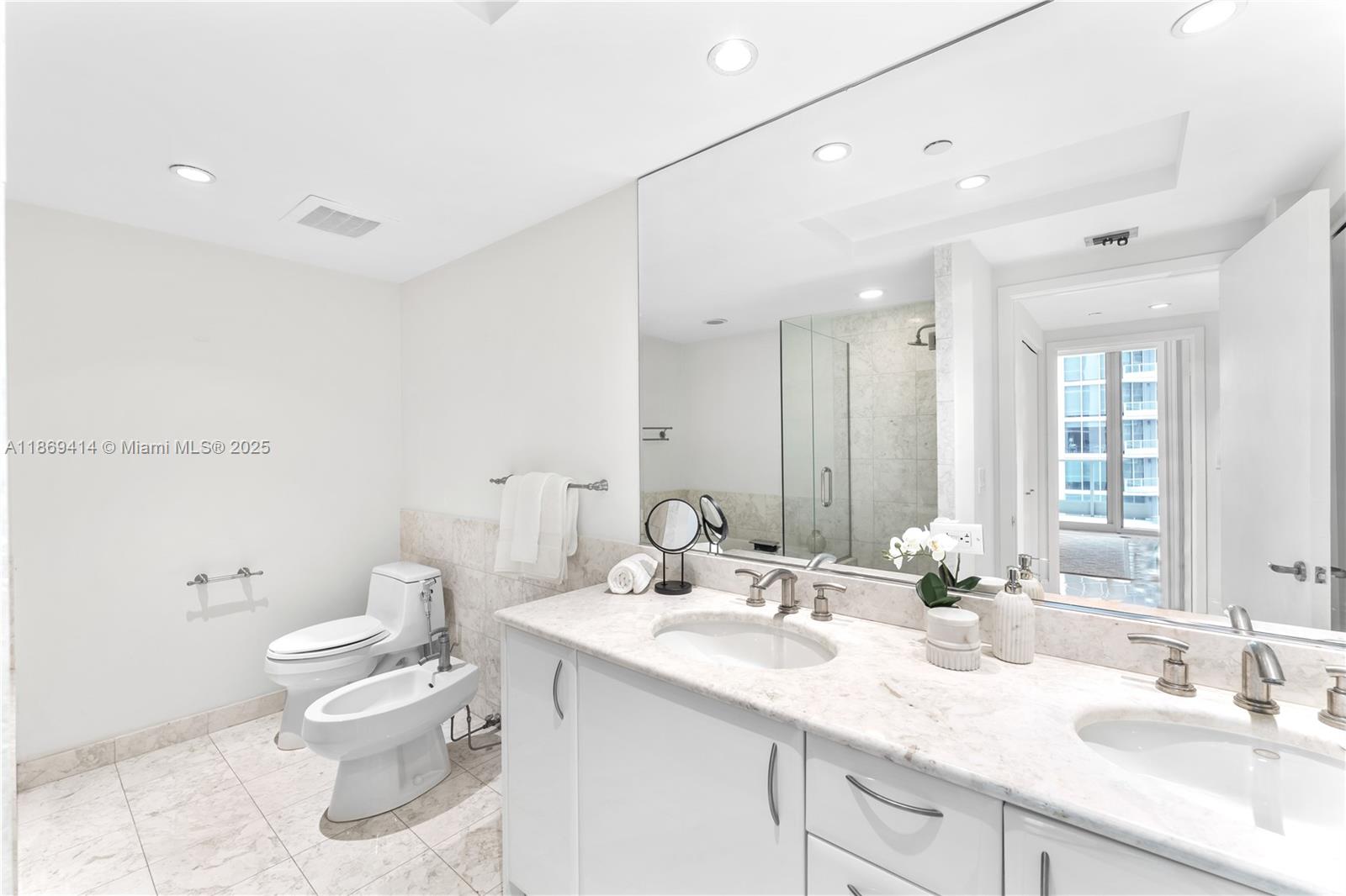 1331 Brickell Bay Drive, Unit 1706 Miami, FL 33131 - Photo 12 of 17 a bathroom with a granite countertop sink a toilet and a mirror
