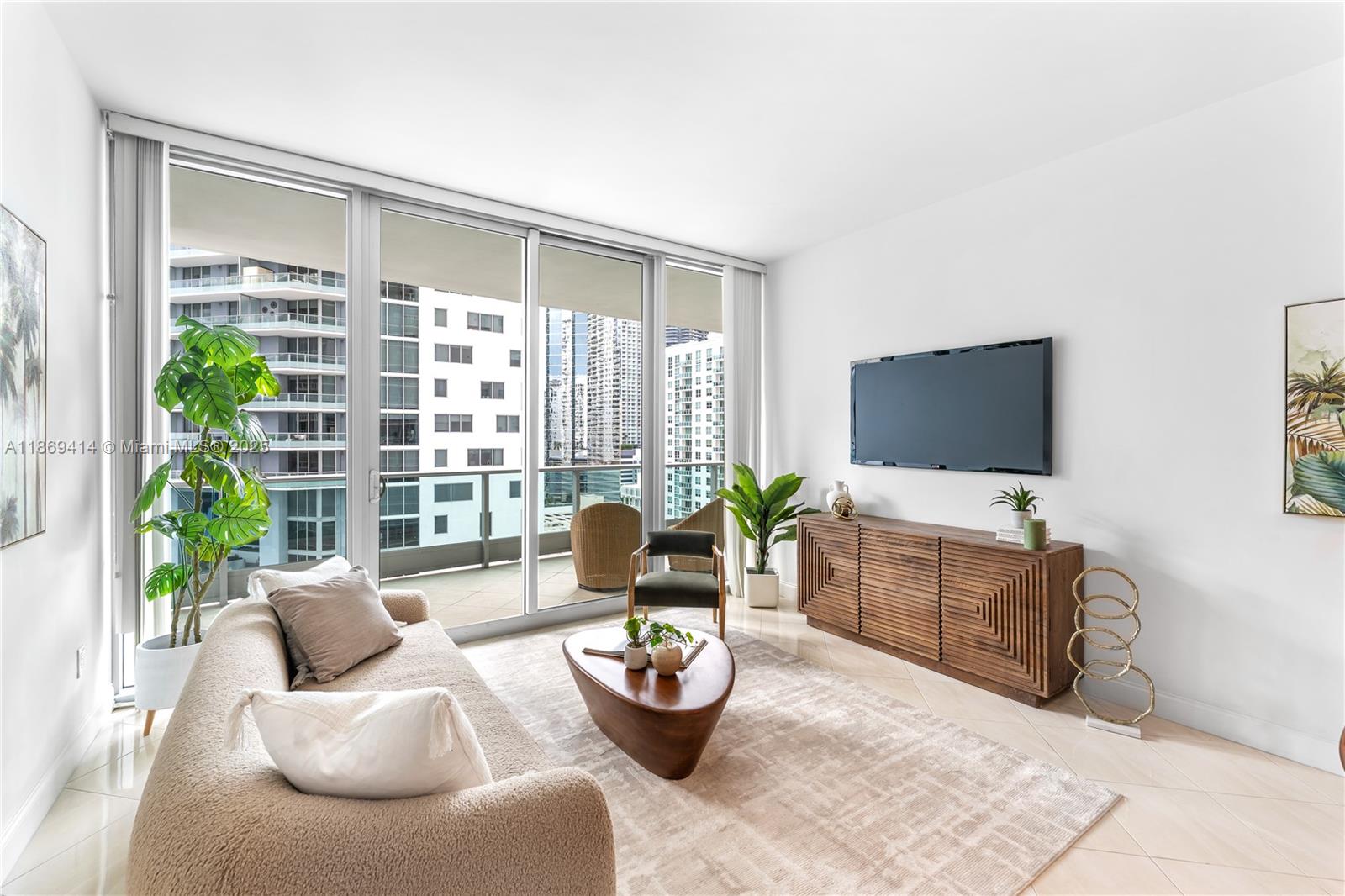 1331 Brickell Bay Drive, Unit 1706 Miami, FL 33131 - Photo 3 of 17 a living room with furniture and a flat screen tv