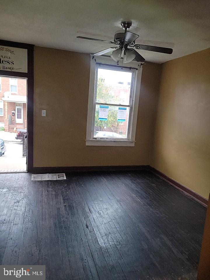 3011 Kenyon Avenue Baltimore, MD 21213 - Photo 3 of 14 an empty room with wooden floor and windows