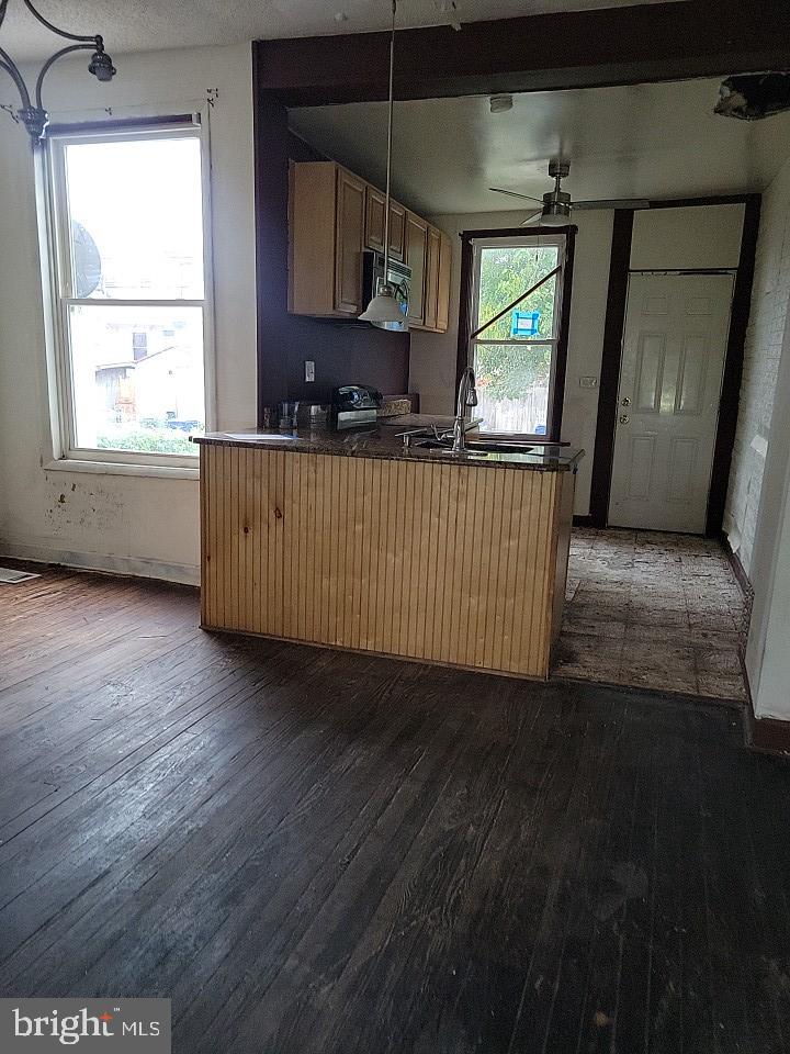 3011 Kenyon Avenue Baltimore, MD 21213 - Photo 6 of 14 a kitchen with stainless steel appliances wooden floors wooden cabinets a window and a sink