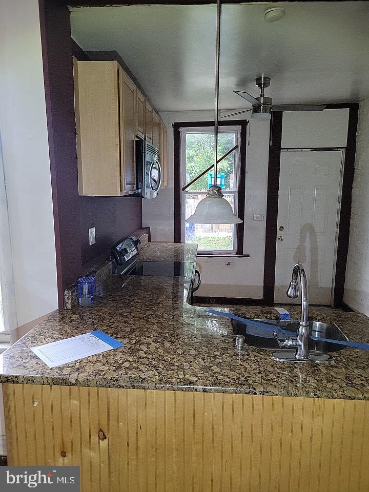 3011 Kenyon Avenue Baltimore, MD 21213 - Photo 7 of 14 a kitchen with a granite countertop sink and a mirror