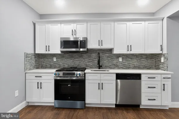 a kitchen with white cabinets and stainless steel appliances