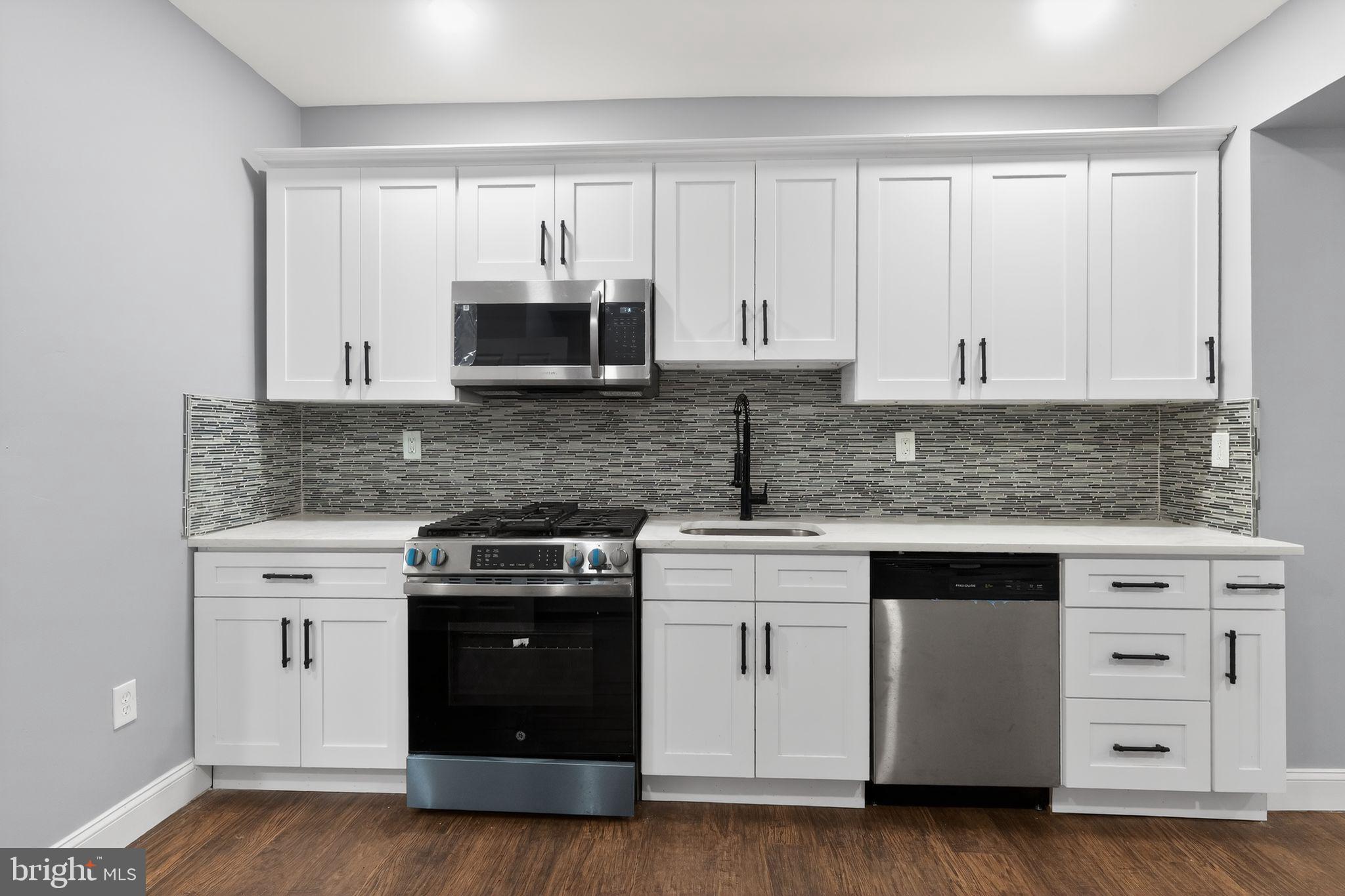 5018 Belair Road Baltimore, MD 21206 - Photo 11 of 32 a kitchen with white cabinets and stainless steel appliances