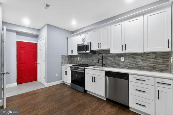 a kitchen with granite countertop a stove top oven sink and cabinets
