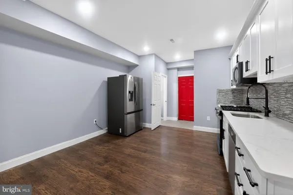 a view of kitchen with stainless steel appliances granite countertop a refrigerator and a sink