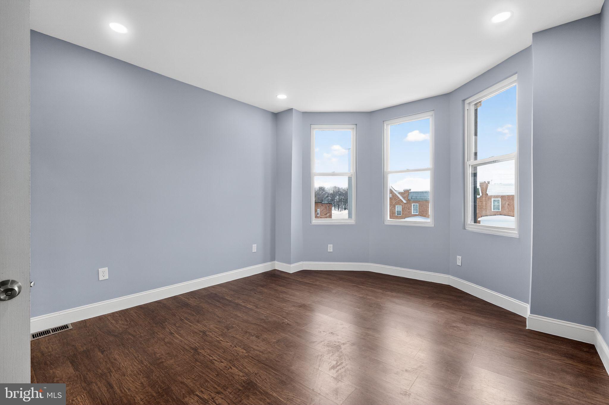 5018 Belair Road Baltimore, MD 21206 - Photo 16 of 32 an empty room with wooden floor and windows