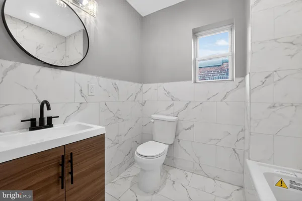 a bathroom with a sink mirror and toilet