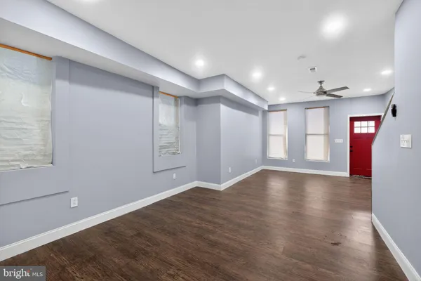 a view of an empty room with window and wooden floor