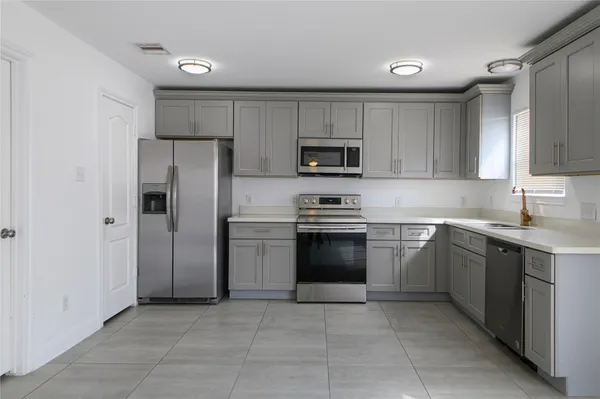 a kitchen with cabinets stainless steel appliances and a window