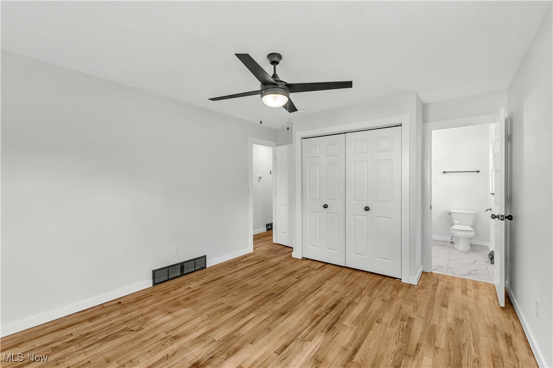 7843 Stone Road Medina, OH 44256 - Photo 15 of 27 Unfurnished bedroom featuring a closet, light wood-style floors, baseboards, a ceiling fan, and ensuite bathroom