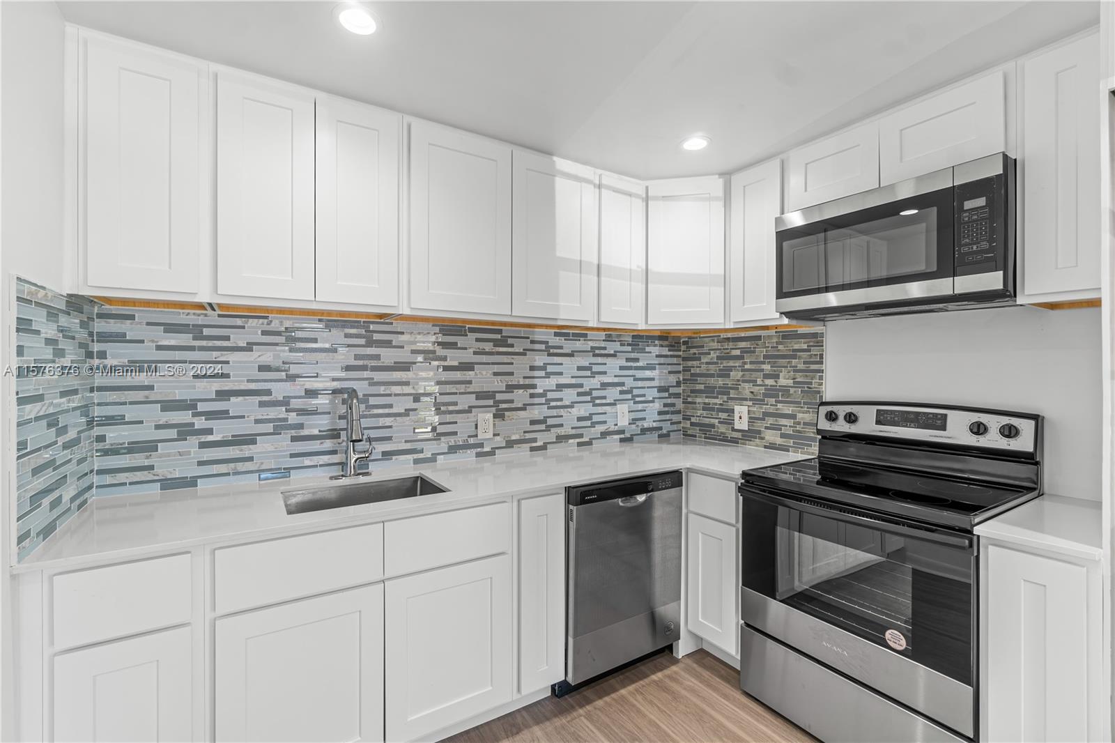 a kitchen with stainless steel appliances white cabinets and a stove a oven