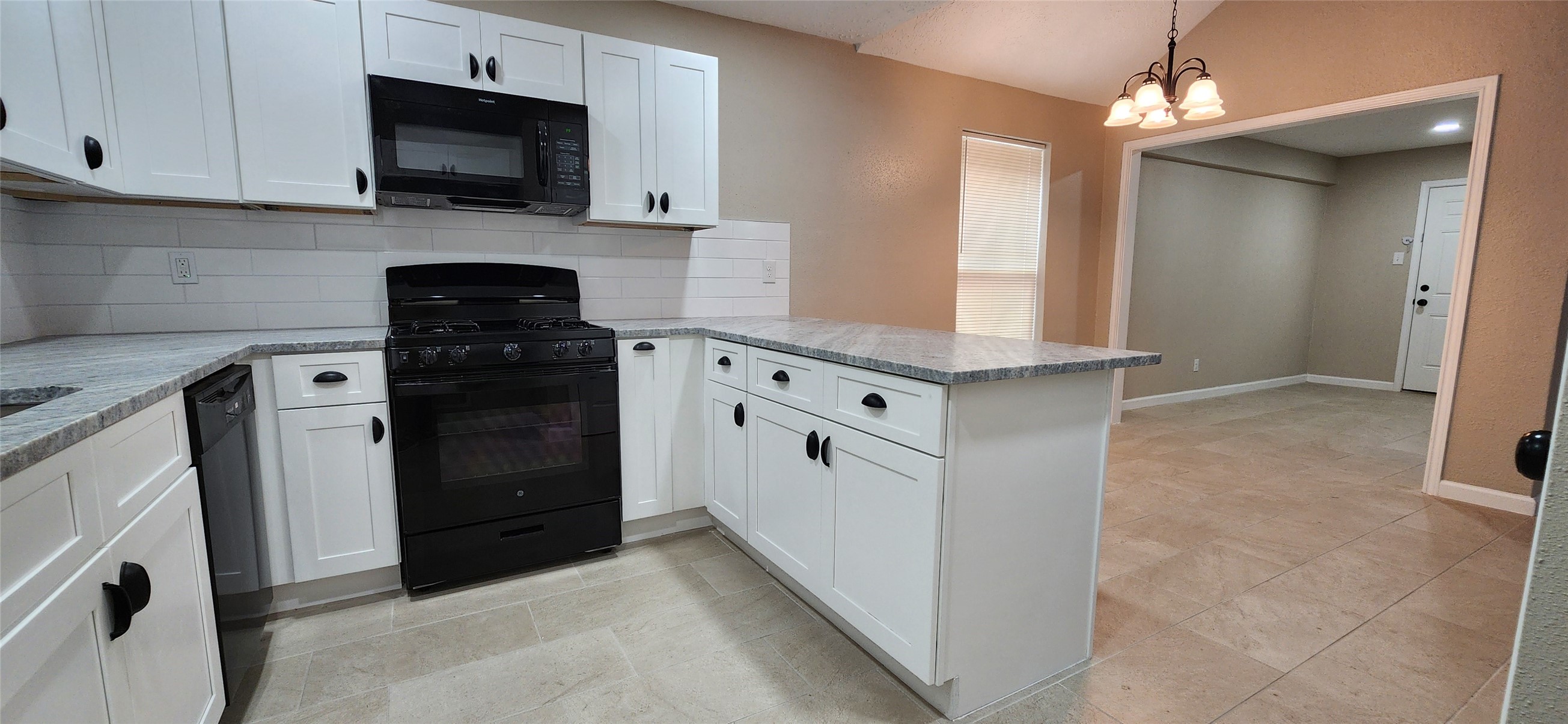 128 Lasso Street Angleton, TX 77515 - Photo 12 of 30 a kitchen with stainless steel appliances granite countertop a stove a microwave and a refrigerator