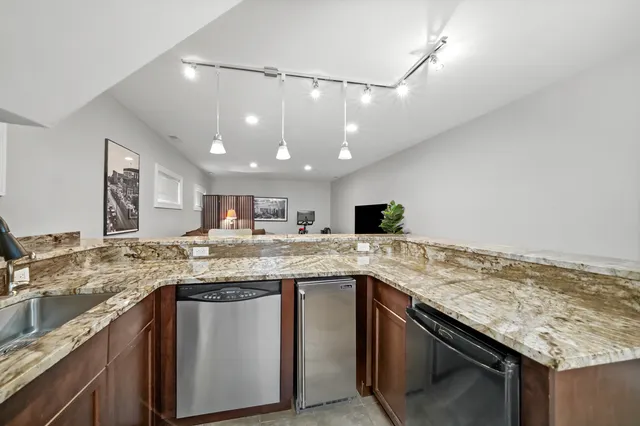 a kitchen with a sink and a stove top oven with wooden floor