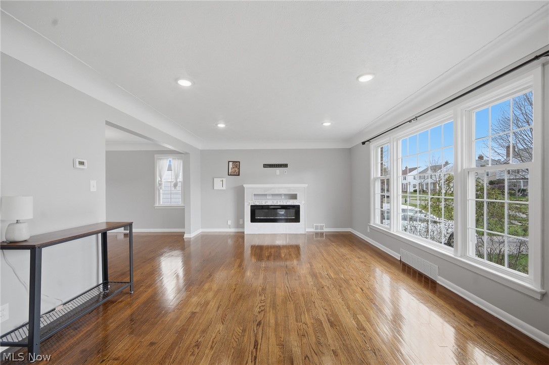 3722 Lindholm Road Shaker Heights, OH 44120 - Photo 6 of 34 Spacious living area featuring hardwood floors, a white fireplace with an insert, large windows providing abundant natural light, and recessed lighting
