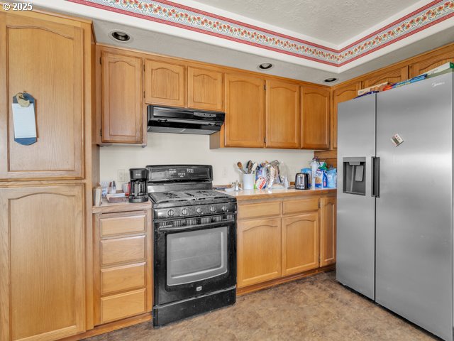 6593 Rippling Brook Drive Southeast Salem, OR 97317 - Photo 10 of 48 a kitchen with stainless steel appliances granite countertop a refrigerator a stove and a sink with wooden floor