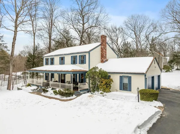 a front view of a house with a yard covered with snow