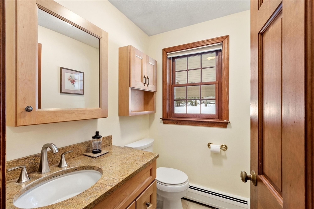 53 Throne Hill Road Groton, MA 01450 - Photo 13 of 38 a bathroom with a granite countertop sink toilet and painting on the wall
