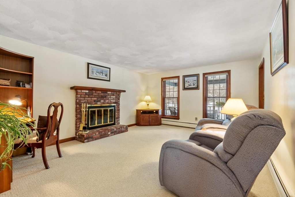 53 Throne Hill Road Groton, MA 01450 - Photo 15 of 38 a living room with furniture a fireplace and a flat screen tv