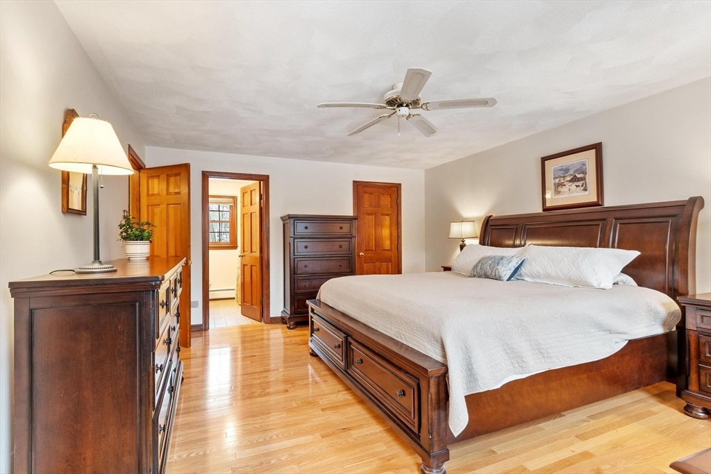 53 Throne Hill Road Groton, MA 01450 - Photo 20 of 38 a spacious bedroom with a bed and a chandelier
