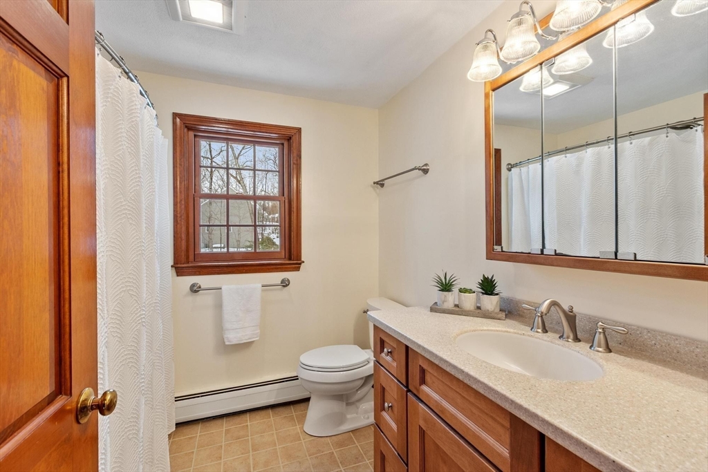 53 Throne Hill Road Groton, MA 01450 - Photo 26 of 38 a bathroom with a granite countertop sink mirror vanity and toilet