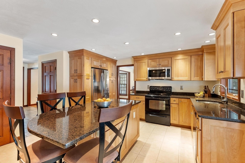53 Throne Hill Road Groton, MA 01450 - Photo 7 of 38 a kitchen with stainless steel appliances granite countertop a stove top oven a sink a dining table and chairs