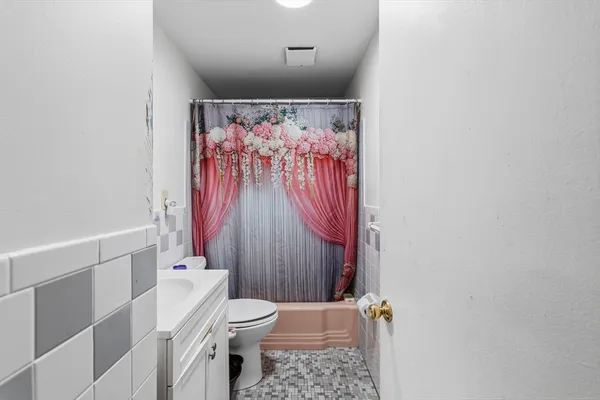 a bathroom with a toilet and a shower curtain