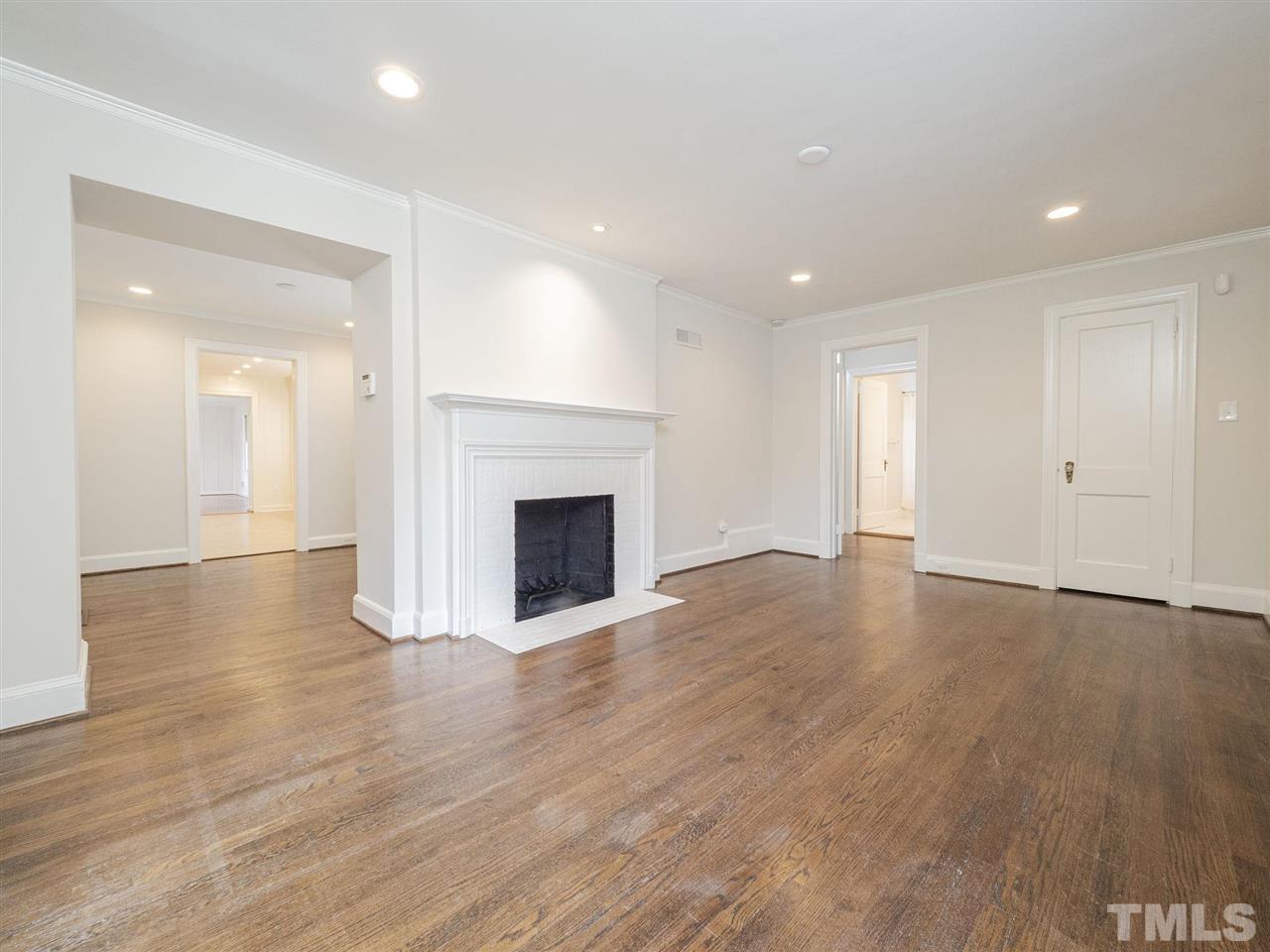 2804 Anderson Drive Raleigh, NC 27608 - Photo 5 of 23 a view of empty room with wooden floor and fireplace