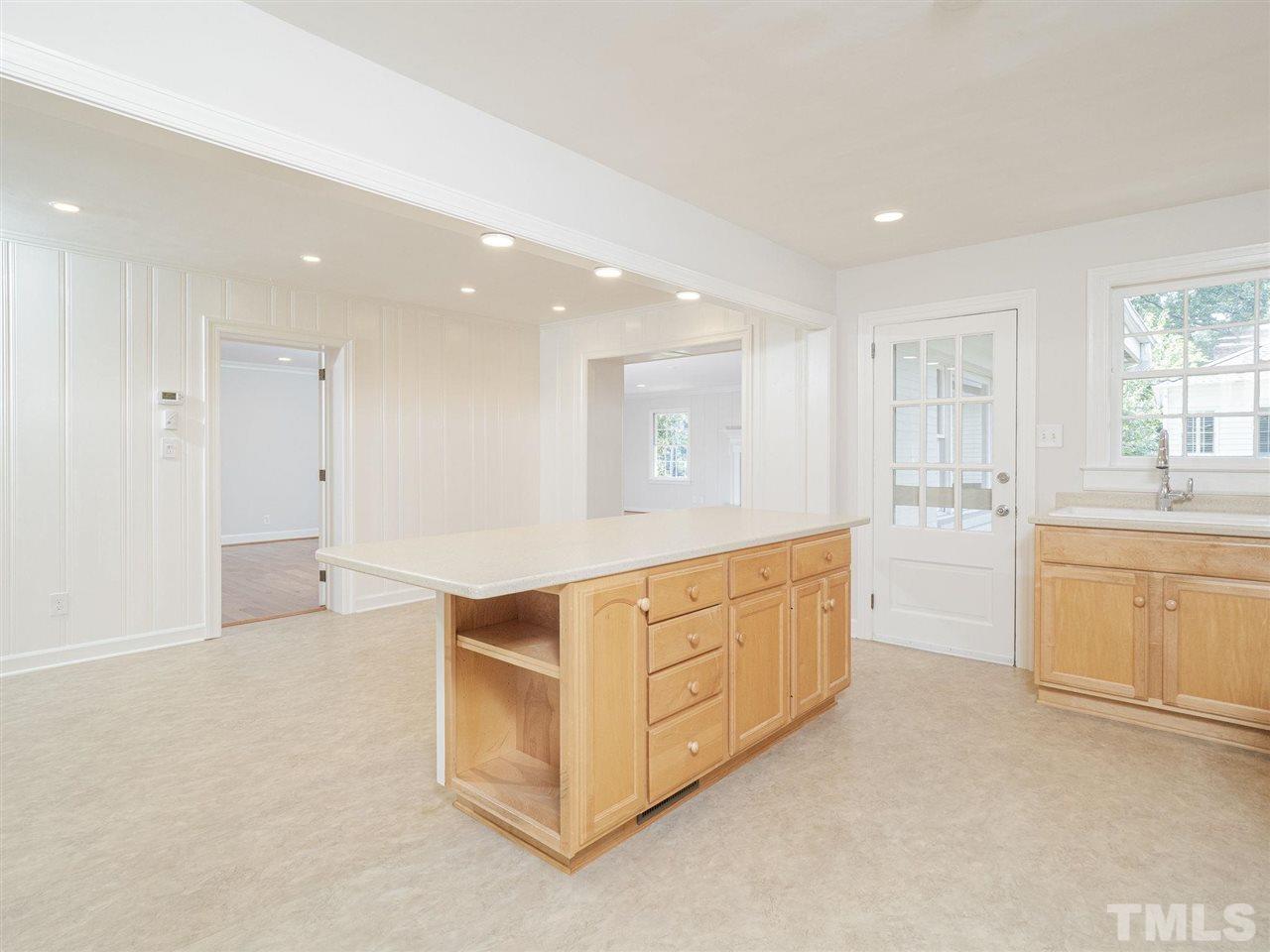 2804 Anderson Drive Raleigh, NC 27608 - Photo 9 of 23 a large white kitchen with stainless steel appliances cabinets a sink and a large window