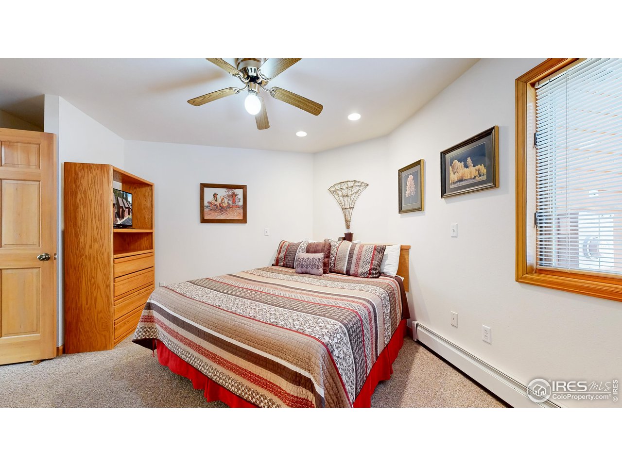 2120 Fall River Road, Unit 2 Estes Park, CO 80517 - Photo 14 of 39 a bedroom with a bed and a chandelier