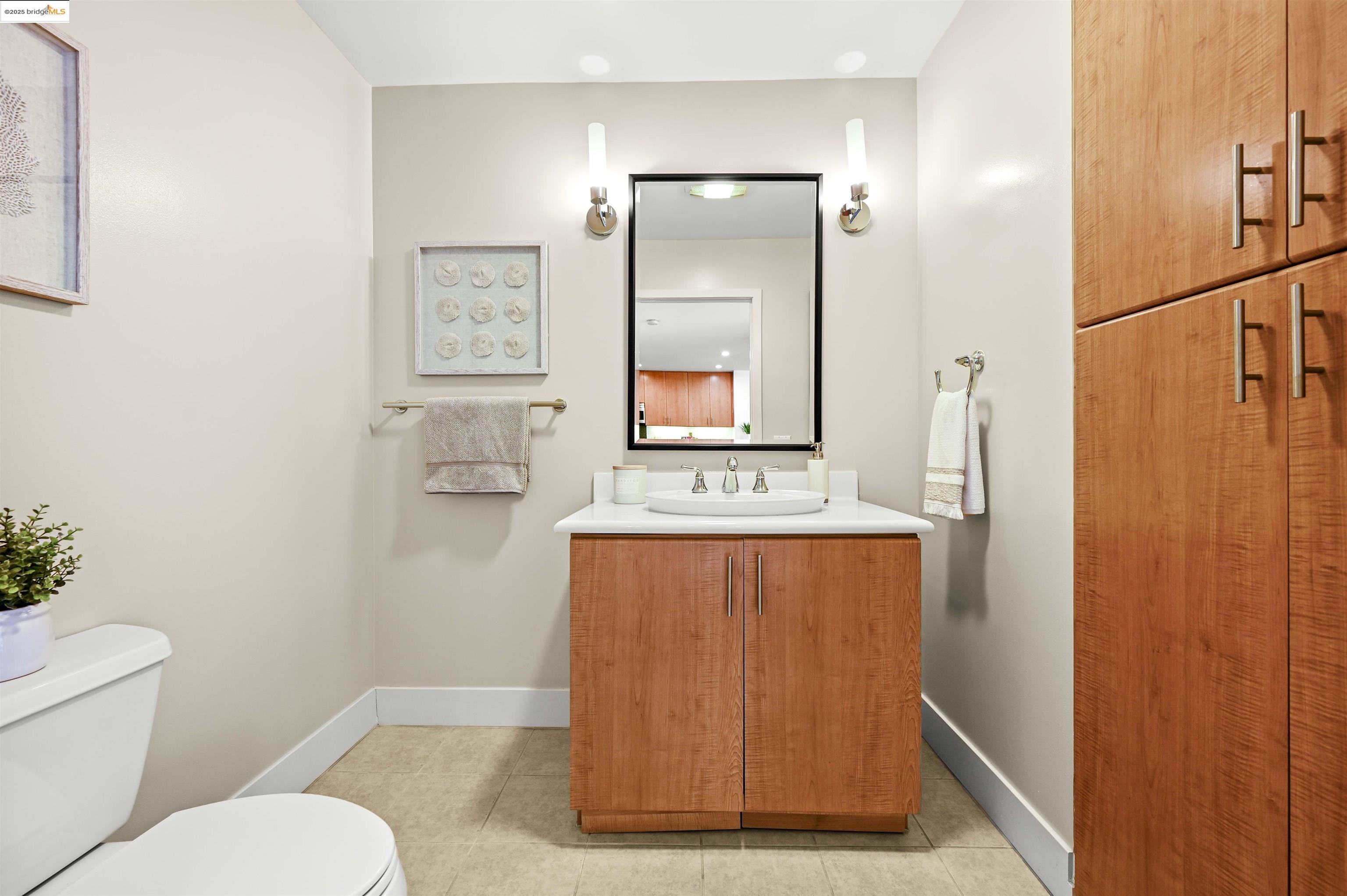 438 West Grand Avenue, Unit 422 Oakland, CA 94612 - Photo 22 of 52 Half bathroom with vanity and light tile patterned flooring