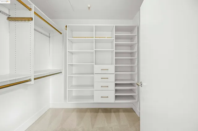 a view of walk in closet with empty racks
