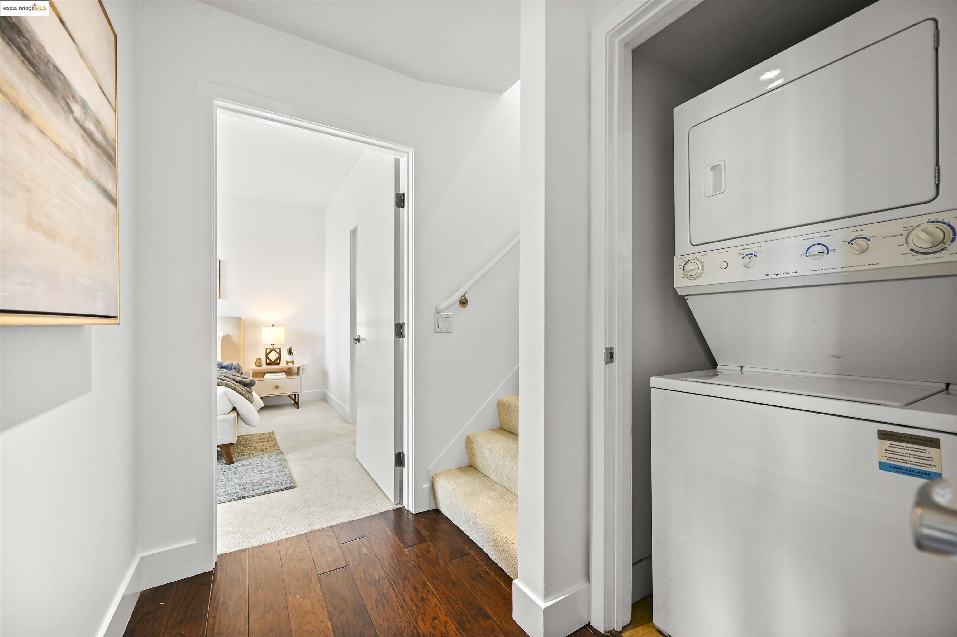 438 West Grand Avenue, Unit 422 Oakland, CA 94612 - Photo 38 of 52 Laundry area with dark wood finished floors and stacked washer / dryer