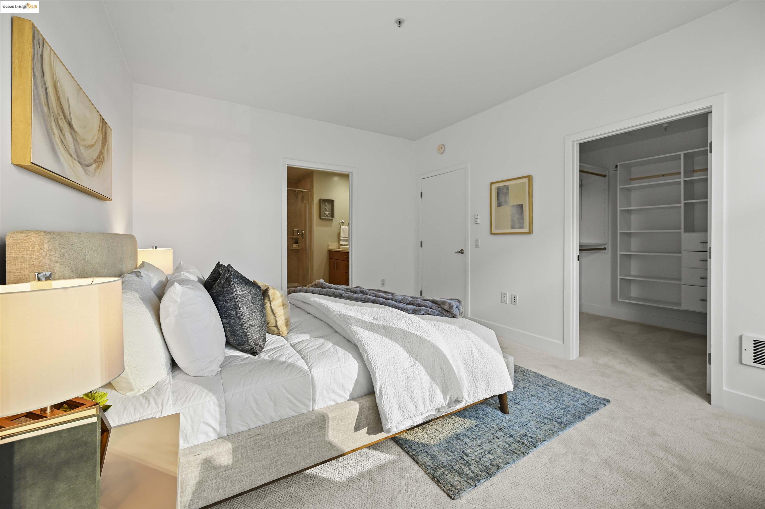 438 West Grand Avenue, Unit 422 Oakland, CA 94612 - Photo 39 of 52 Carpeted bedroom featuring a walk in closet and ensuite bathroom