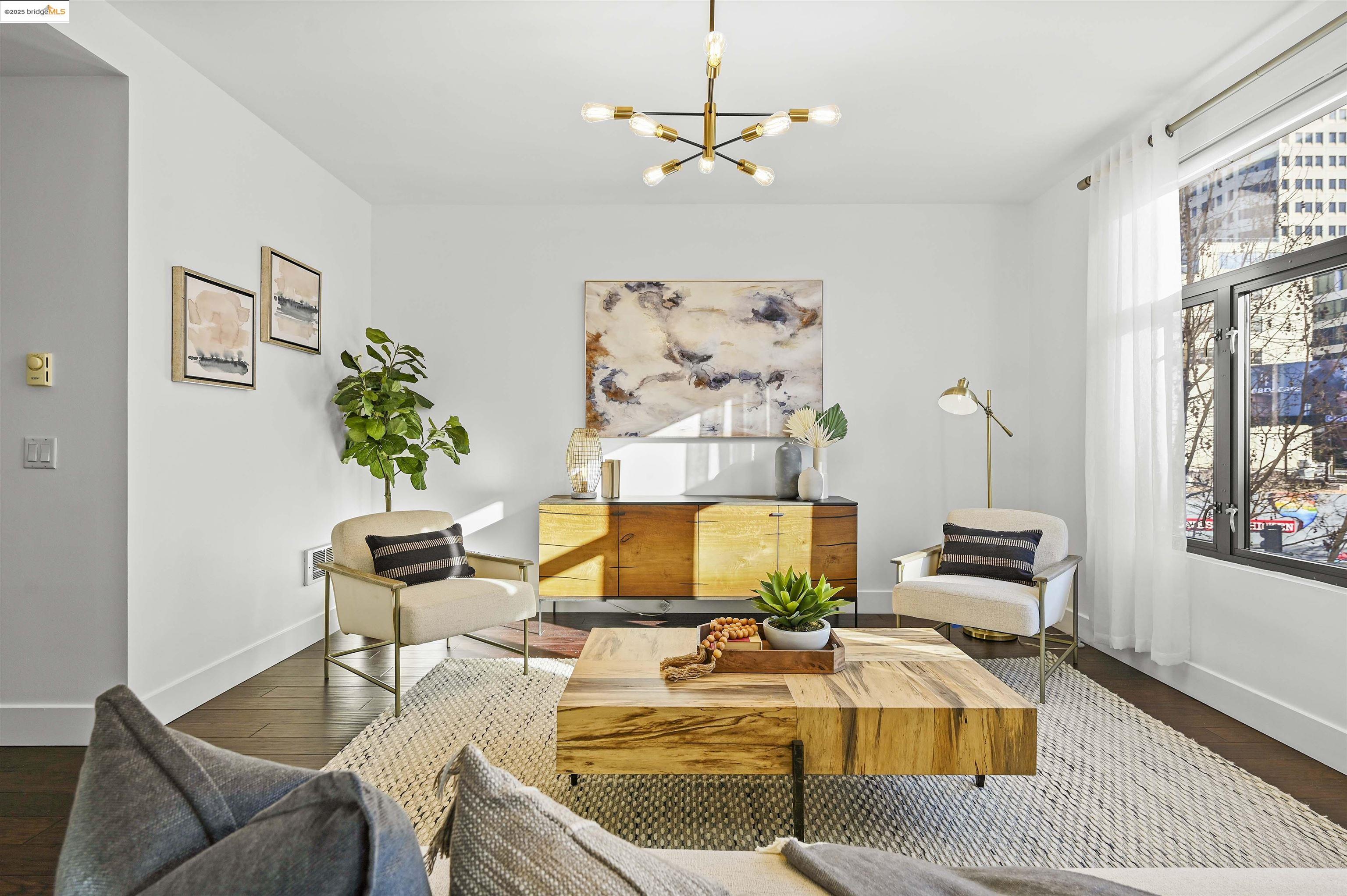 438 West Grand Avenue, Unit 422 Oakland, CA 94612 - Photo 5 of 52 Living area with wood finished floors and a chandelier