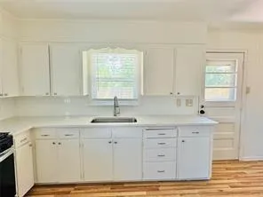 a kitchen with stainless steel appliances granite countertop a sink window and cabinets