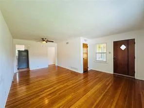 a view of empty room with window and wooden floor