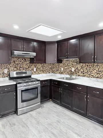 a kitchen with stainless steel appliances granite countertop a sink stove and cabinets
