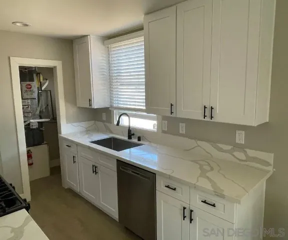 a kitchen with granite countertop a sink and a stove
