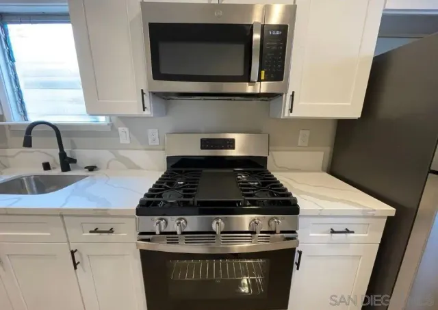 a stove top oven sitting inside of a kitchen
