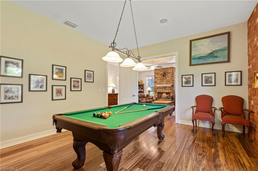 2116 Harlans Run Naples, FL 34105 - Photo 18 of 35 Rec room with wood finished floors, pool table, and a fireplace