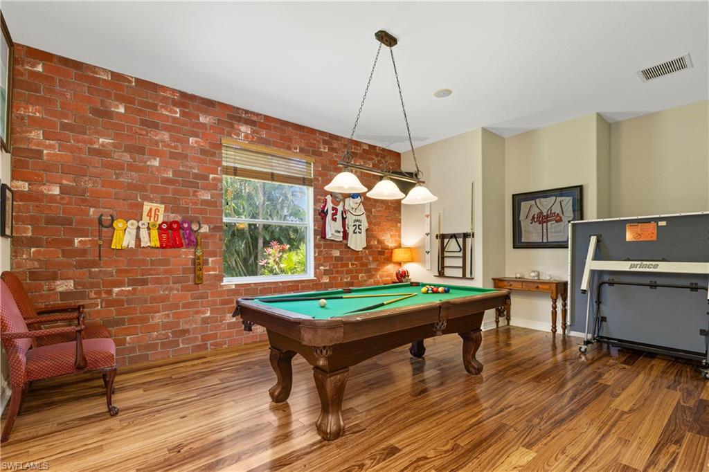 2116 Harlans Run Naples, FL 34105 - Photo 19 of 35 Rec room with pool table, brick wall, and wood finished floors