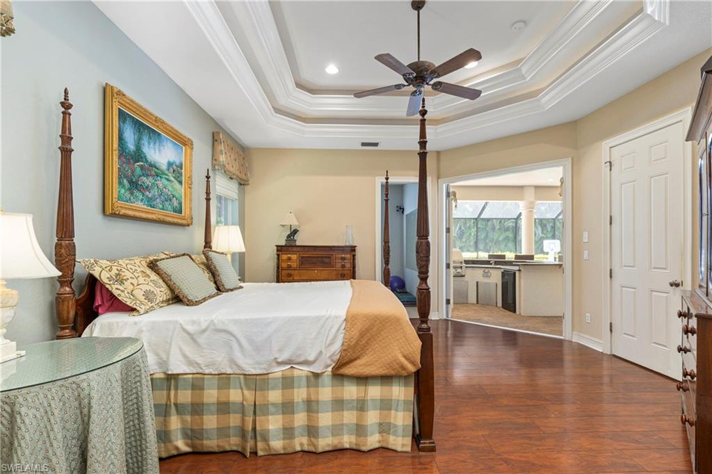 2116 Harlans Run Naples, FL 34105 - Photo 24 of 35 Bedroom featuring crown molding, dark wood-style flooring, a tray ceiling, recessed lighting, and a ceiling fan