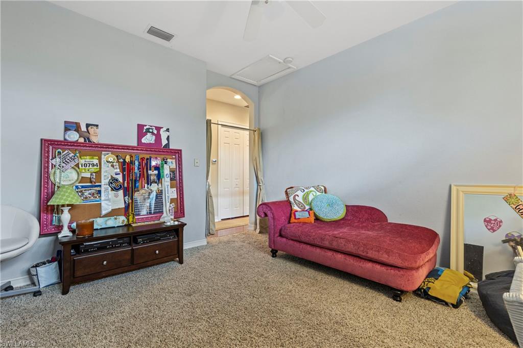 2116 Harlans Run Naples, FL 34105 - Photo 29 of 35 Sitting room featuring carpet floors, ceiling fan, and arched walkways