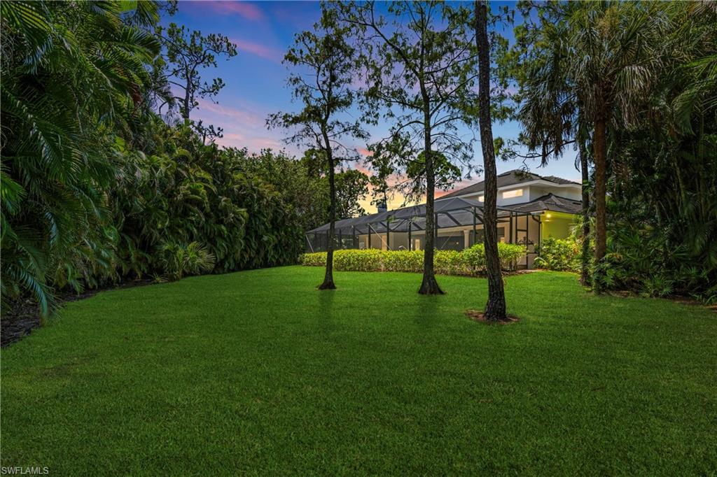 2116 Harlans Run Naples, FL 34105 - Photo 32 of 35 Yard at dusk featuring a lawn and a lanai