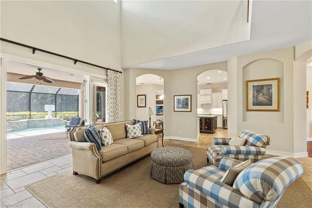 2116 Harlans Run Naples, FL 34105 - Photo 6 of 35 Living room with arched walkways, a ceiling fan, recessed lighting, a high ceiling, and a sunroom