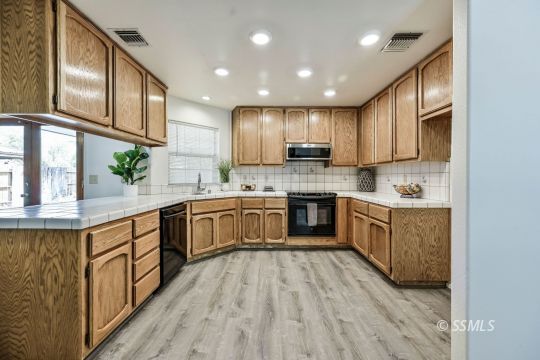 1213 Alysa Court Ridgecrest, CA 93555 - Photo 2 of 34 a large kitchen with stainless steel appliances sink a microwave and cabinets