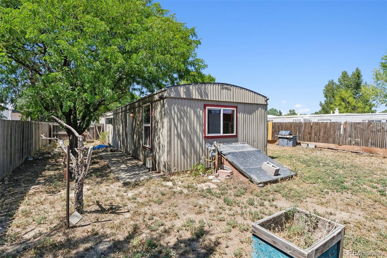 1044 Mac Davidson Circle Dacono, CO 80514 - Photo 21 of 25 a backyard of a house with barbeque oven
