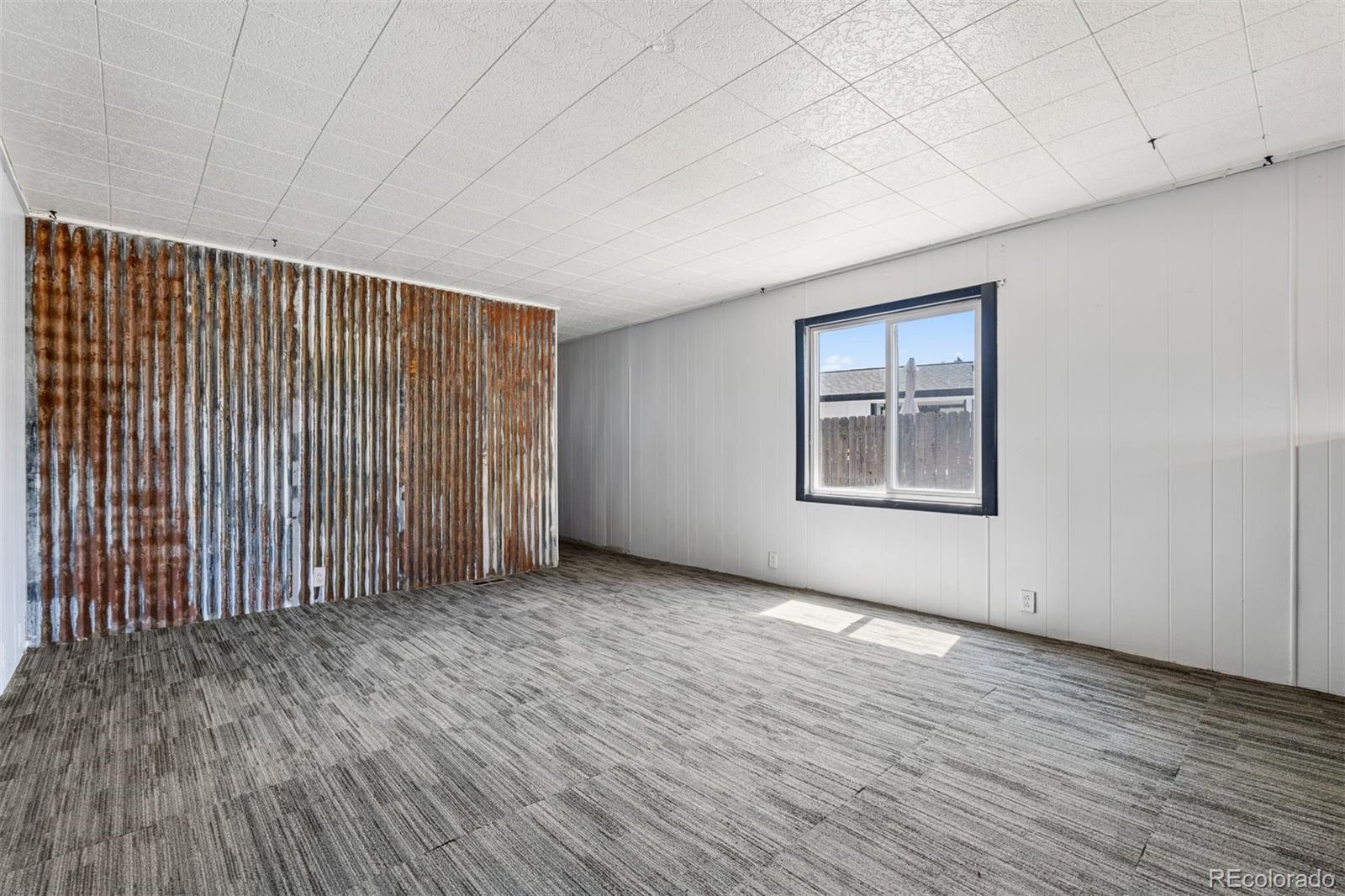 1044 Mac Davidson Circle Dacono, CO 80514 - Photo 22 of 25 an empty room with wooden floor and windows